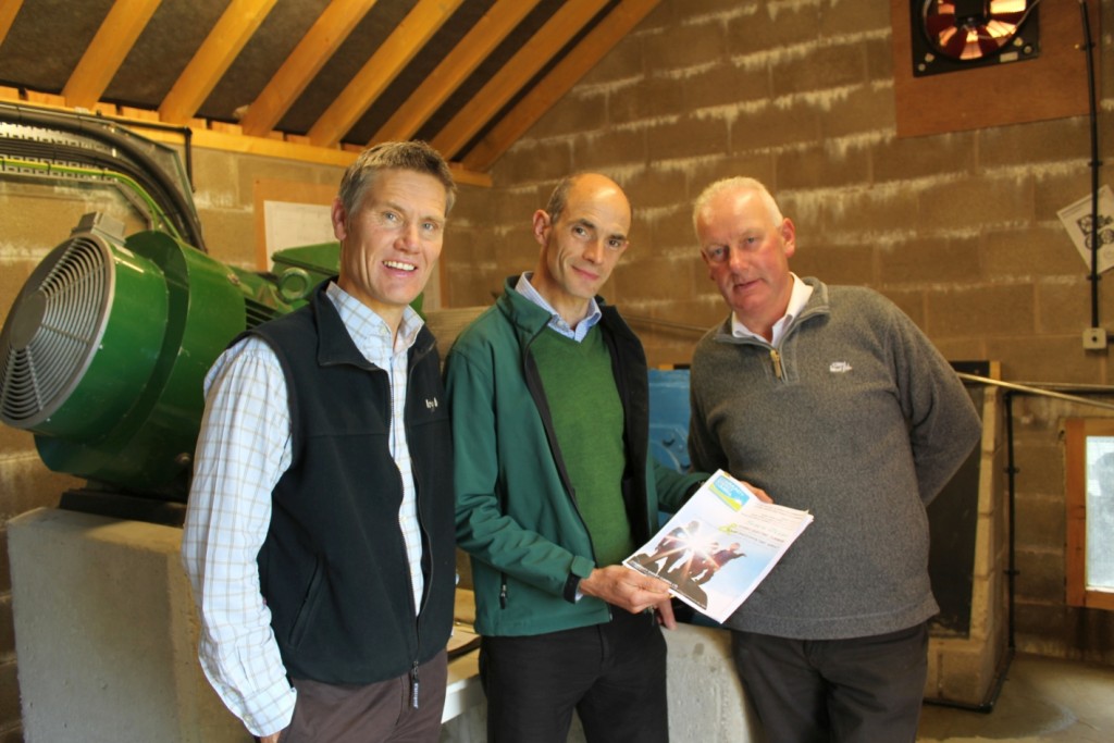 Phil Davies (C), Founding Director of Community Energy Cumbria shows the Share Offer Document to Clive Wickham (L), Partnerships Manager at LDNP and Dave Townley (R), Site Manager for Ellergreen Hydro.