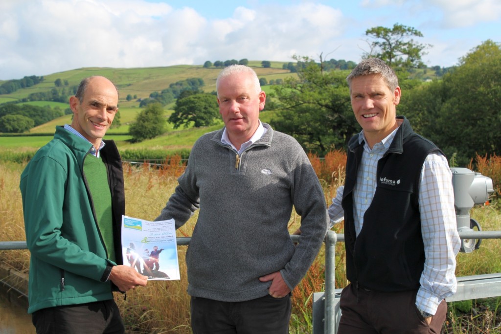Phil Davies (L), Founding Director of Community Energy Cumbria shows the Share Offer Document to Clive Wickham (R), Partnerships Manager at LDNP and Dave Townley (C), Site Manager for Ellergreen Hydro.